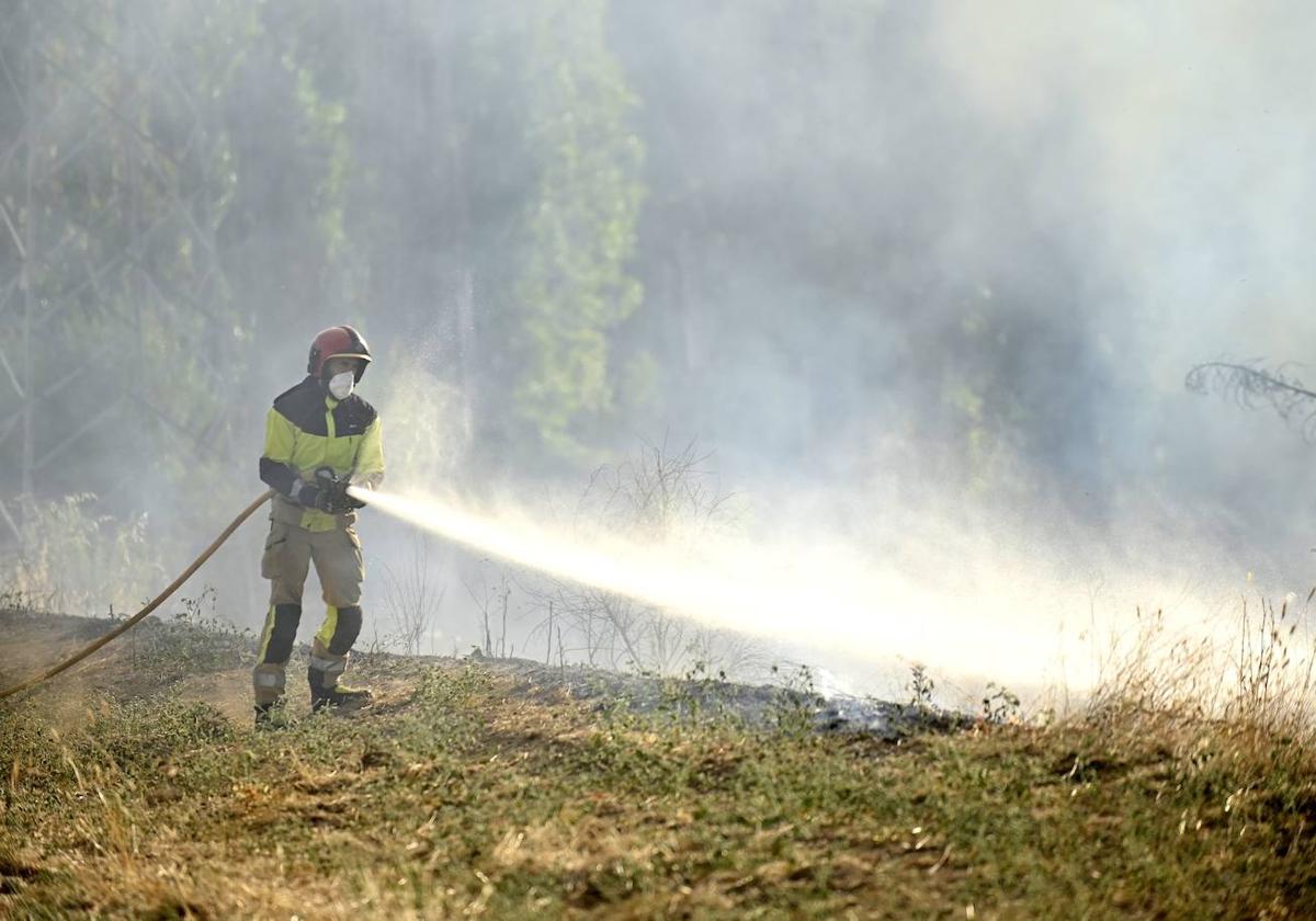 Un bombero trabaja para apagar el fuego junto a Arca Real.