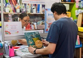 Begoña Martínez atiende a un cliente en la librería Rima, ubicada en La Rondilla.