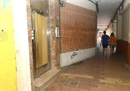 Dos personas pasan junto al lugar de los hechos dos horas después del suceso, cuando aún se podía ver un reguero de sangre frente al portal 10 de la plaza.