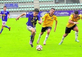 Hugo de Bustos dirige la jugada ante dos rivales de Las Rozas en La Balastera.