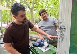 Juan Aguayo y Pablo López, de Kokomo Candilejas, muestran los desperfectos en la cerradura tras el asalto a su caseta.