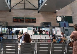 Varios pasajeros revisan en el vestíbulo de Segovia-Guiomar el horario de salida de sus trenes.