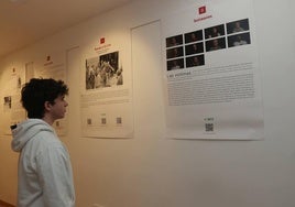 Un joven lee uno de los veintidós paneles que conforman la exposición 'Rolando 2:15-2:45. 50 años de la primera masacre de ETA' en el Aulario.