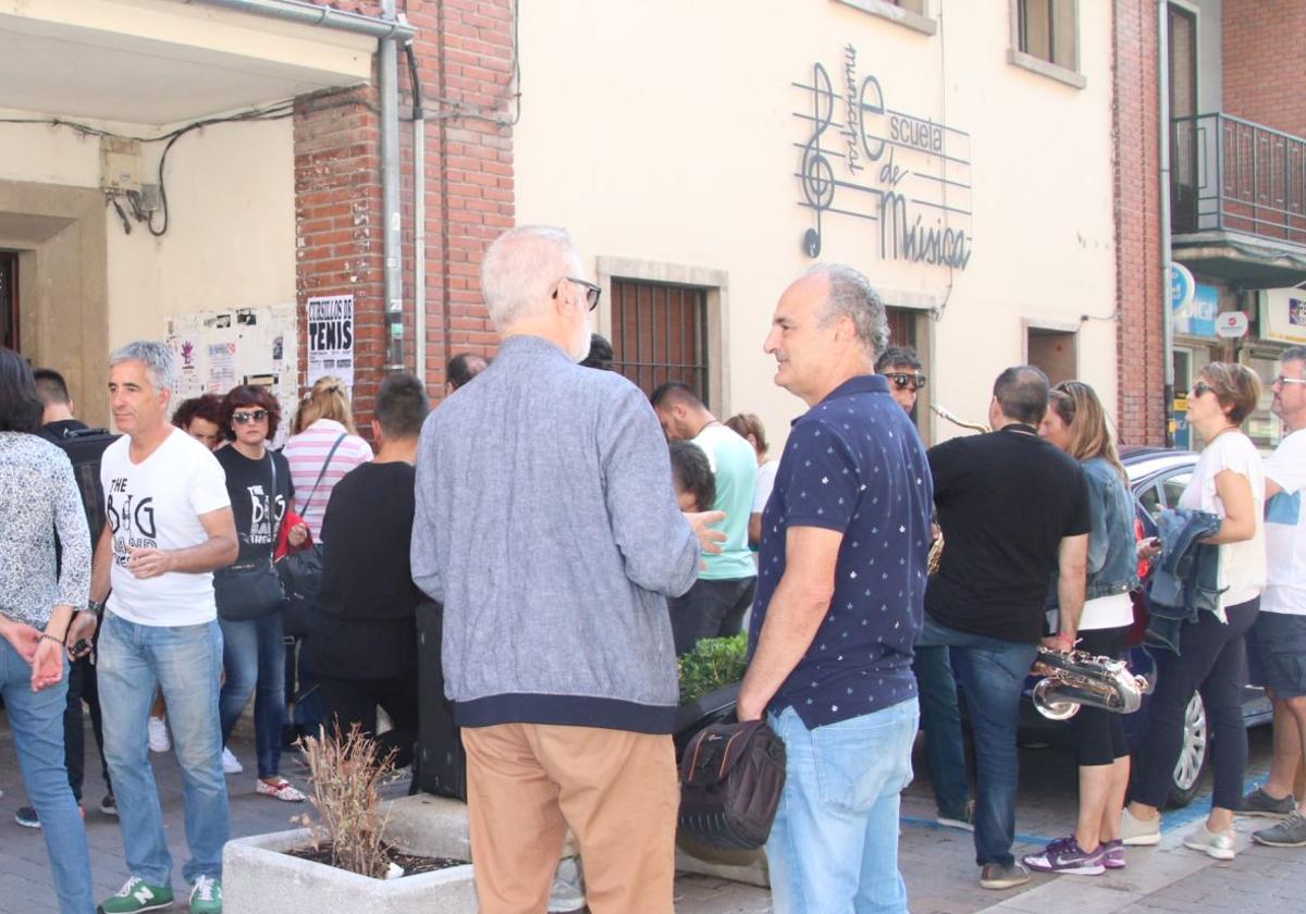 Varias personas se reúnen junto a la fachada de la Escuela de Música de Cuéllar.