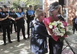 Julia González, superintendente jefa de la Policía Municipal, le entrega un ramos de flores a Dolores, viuda de Daniel Prieto.