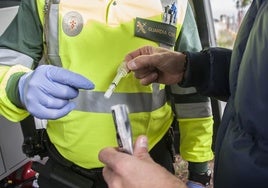 Conductor procede a realizar una prueba de drogas en un control de la Guardia Civil.