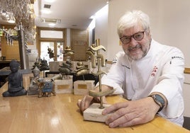 Alfonso García posa en la barra de su restaurante con algunos de los premios obtenidos en su dilatada trayectoria.