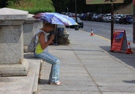 Una mujer se protege del calor el pasado agosto con un paraguas.