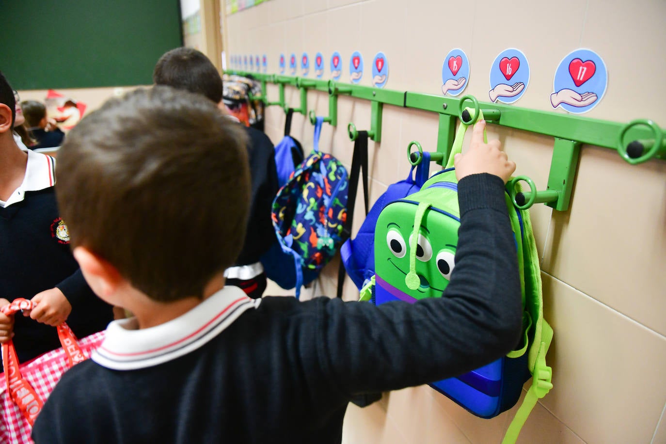 Un niño cuelga su mochila en el primer día de clase en el colegio Huelgas de Valladolid.