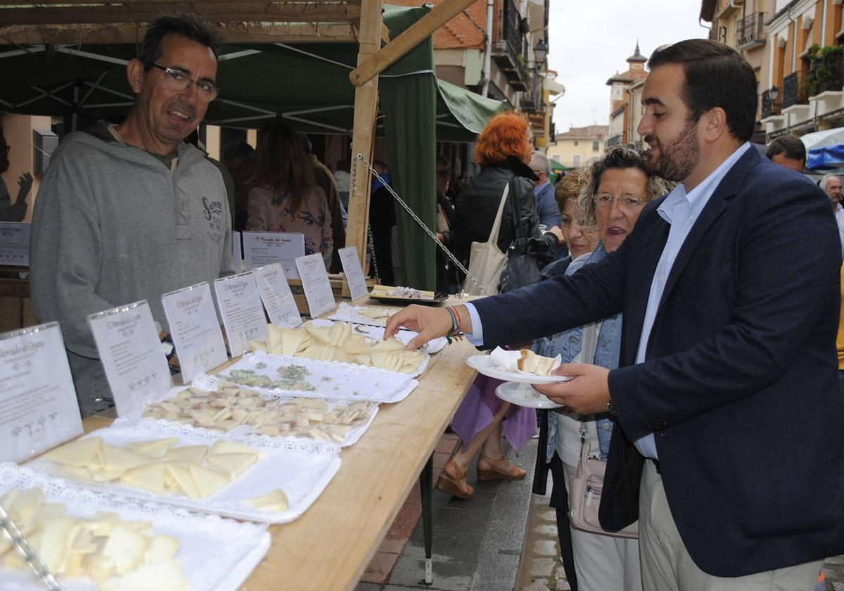 El alcalde, José Ángel Alonso, anima a sus convecinos a participar en una degustación de queso en una edición anterior del mercado.