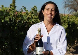 Beatriz Moro, presidenta de la Bodega Win Sin Alcohol, enseñando una botella de espumoso en los viñedos.