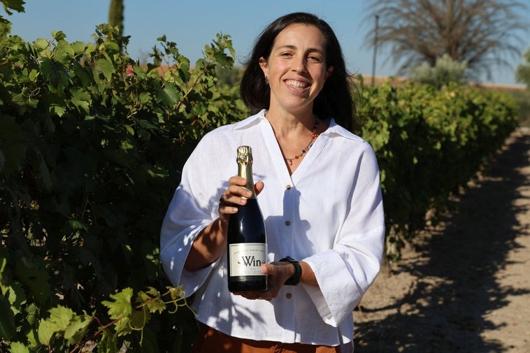 Beatriz Moro, presidenta de la Bodega Win Sin Alcohol, enseñando una botella de espumoso en los viñedos.