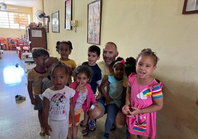 José Manuel Fernández junto a varios niños de la guardería cubana