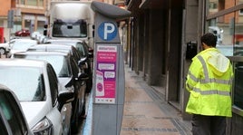 Un controlador de la zona ORA, junto a un parquímetro.