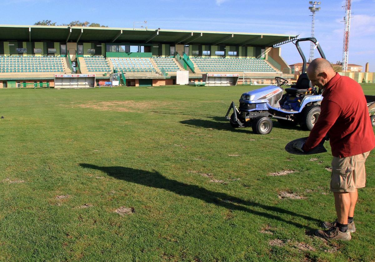 Un operario municipal trabaja en el cuidado del césped de La Albuera en el verano de 2023.