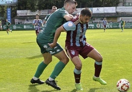 Davo intenta aguantar el balón ante la presión de un rival.