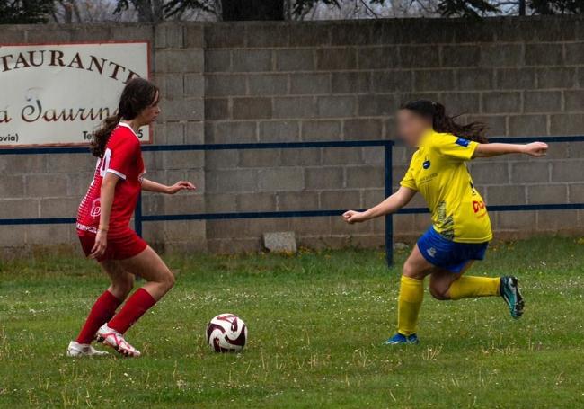 Carla, a la izquierda, lleva el balón ante una rival en un partido.