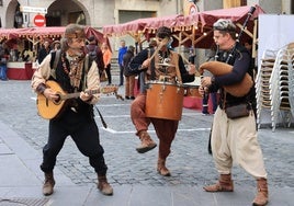 Tres músicos animan las calles en la Plaza de los Mercaderes.