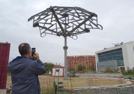 Un hombre fotografía la cúpula que albergará el centro de la plaza de la Ciudad de la Comunicación.