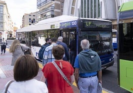 Varios usuarios del nuevo servicio de lanzaderas entre barrios se suben a uno de los autobuses.