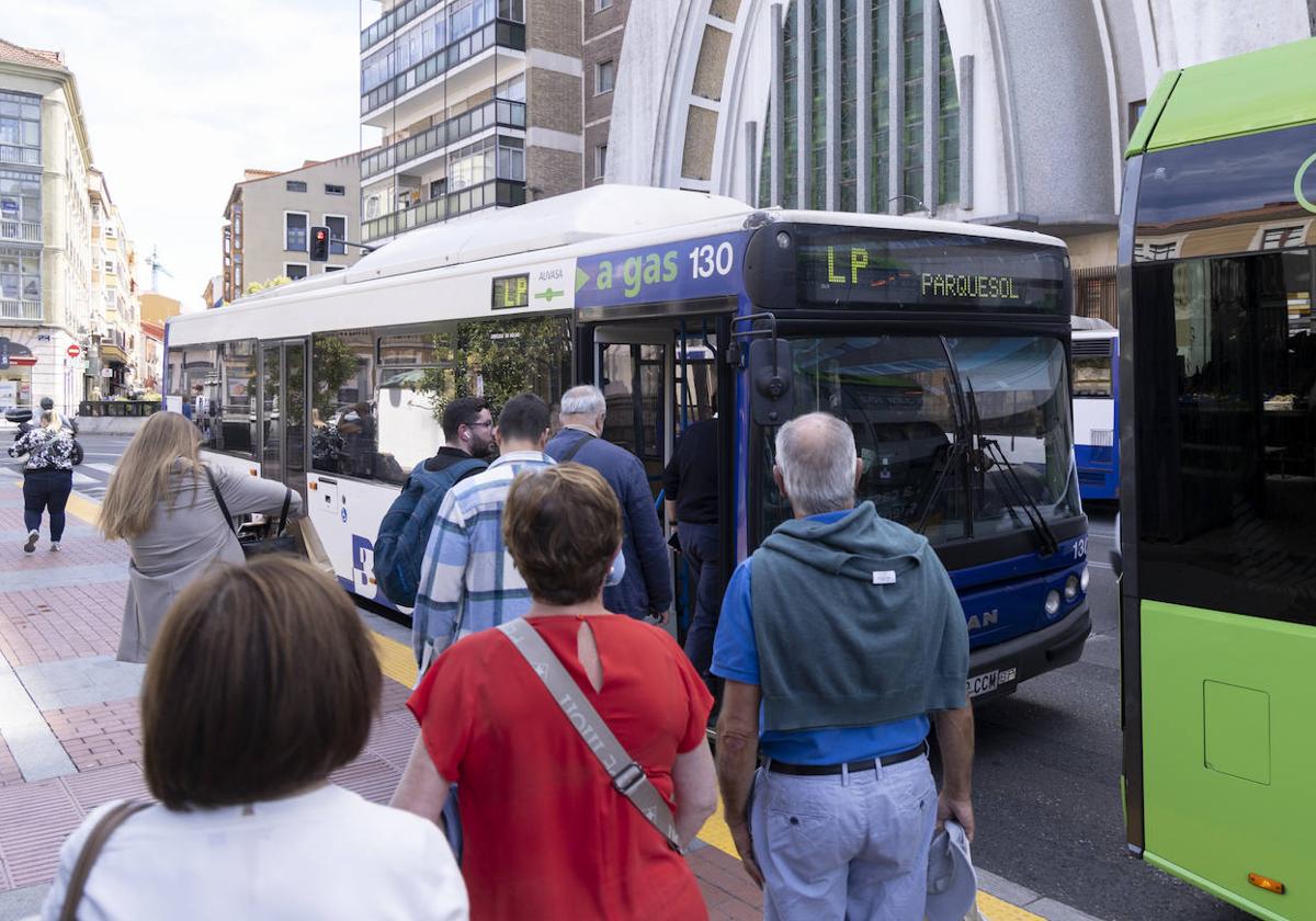 Varios usuarios del nuevo servicio de lanzaderas entre barrios se suben a uno de los autobuses.