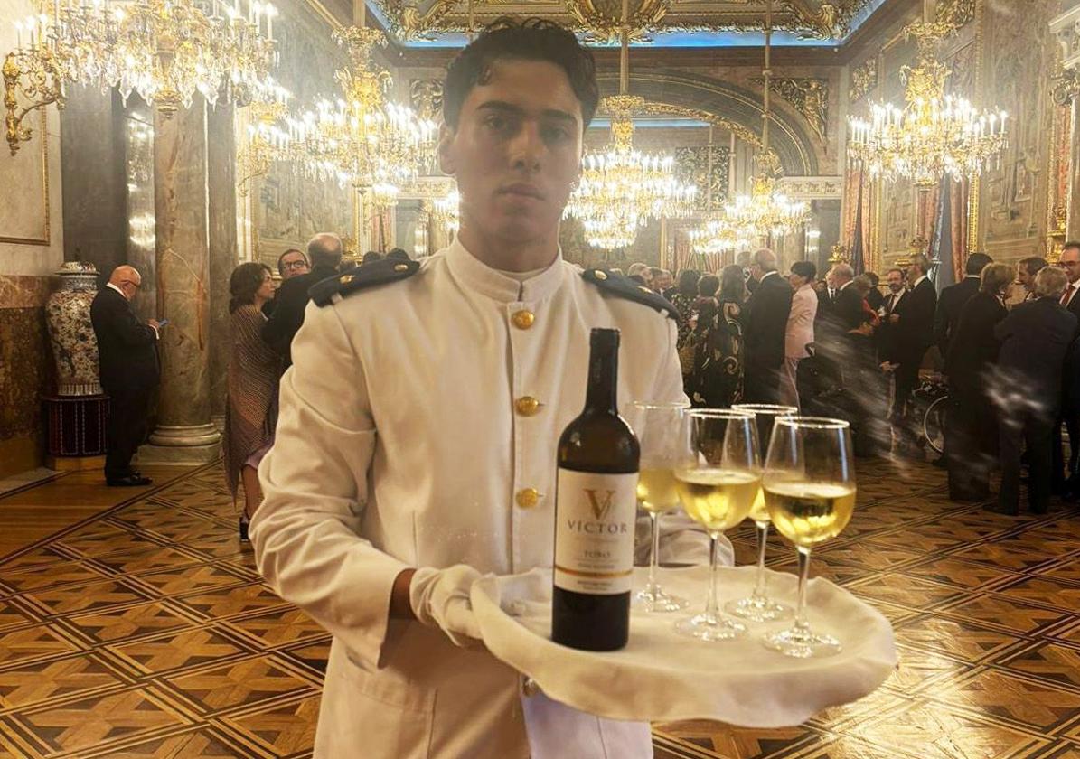 Un camarero posa con uno de los vinos de la Bodega Heredad de Urueña servidos este sábado en el Palacio Real.