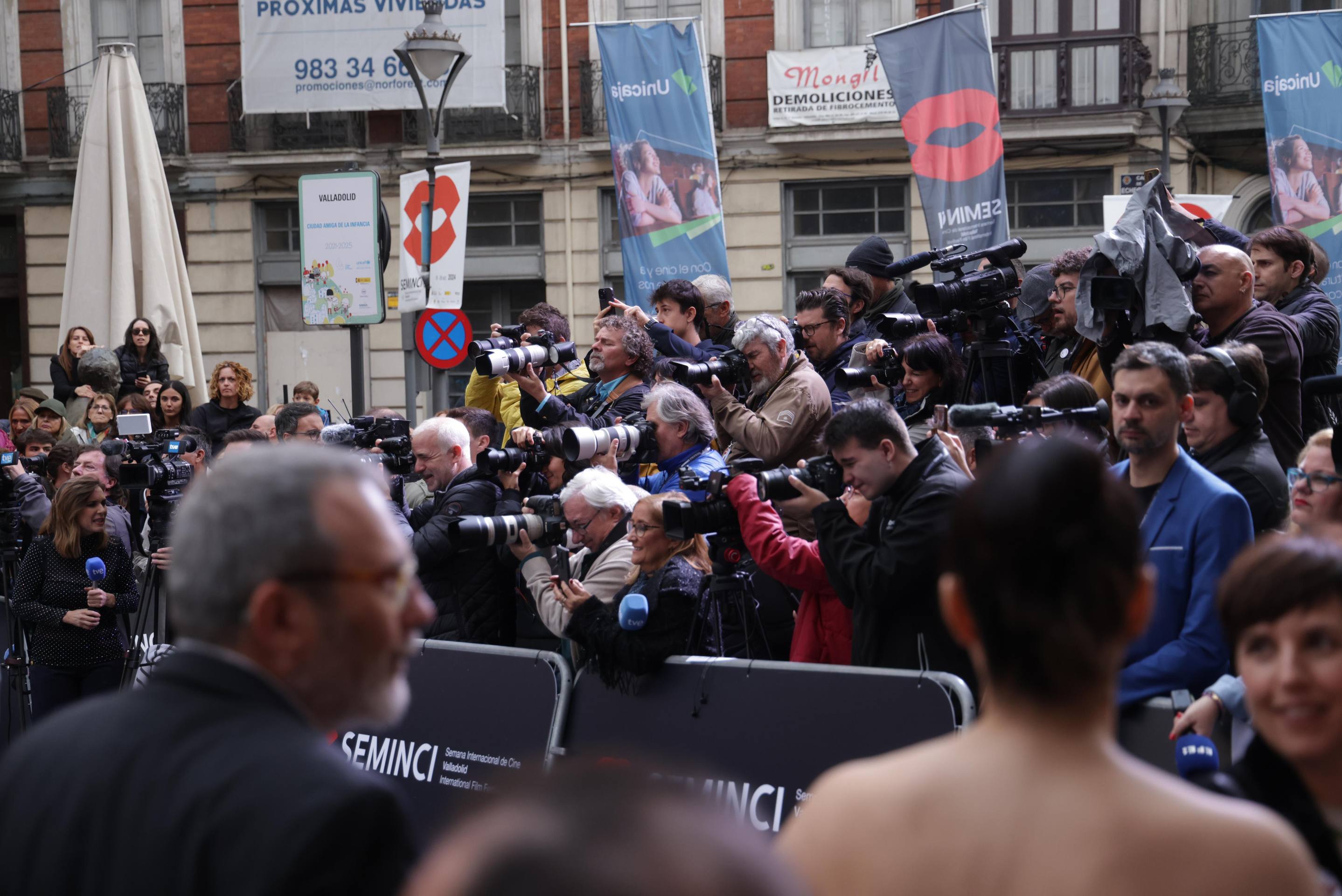 Esta es la otra perspectiva de la alfombra roja de la Seminci 2024. Un muro de fotógrafos y compañeros de medios de comunicaicón de todo el mundo 'hace lucir' a las celebridades y personalidades que desfilan frente al Teatro Calderón