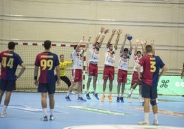 Jugadores del Viveros Herol Nava intentan taponar un lanzamiento del equipo catalán.