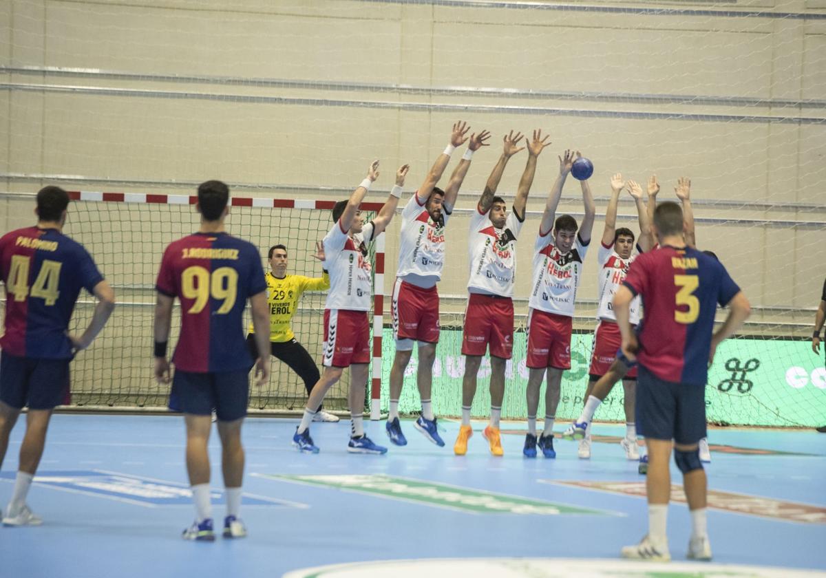 Jugadores del Viveros Herol Nava intentan taponar un lanzamiento del equipo catalán.