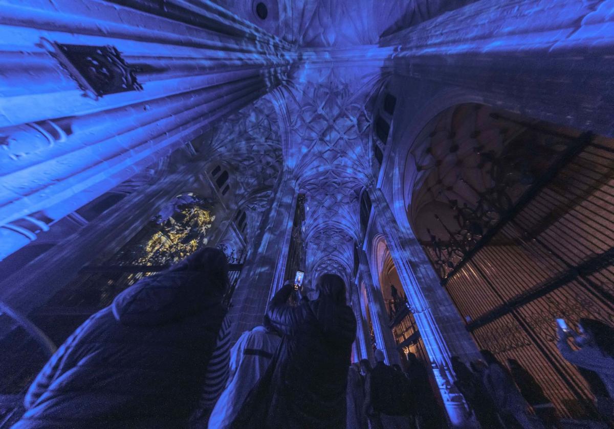 Una persona hace una fotografía del interior de la Catedral durante el espectáculo lumínico.