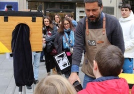 Antonio muestra un negativo a dos niños curiosos, ayer en la plaza de las Sirenas.
