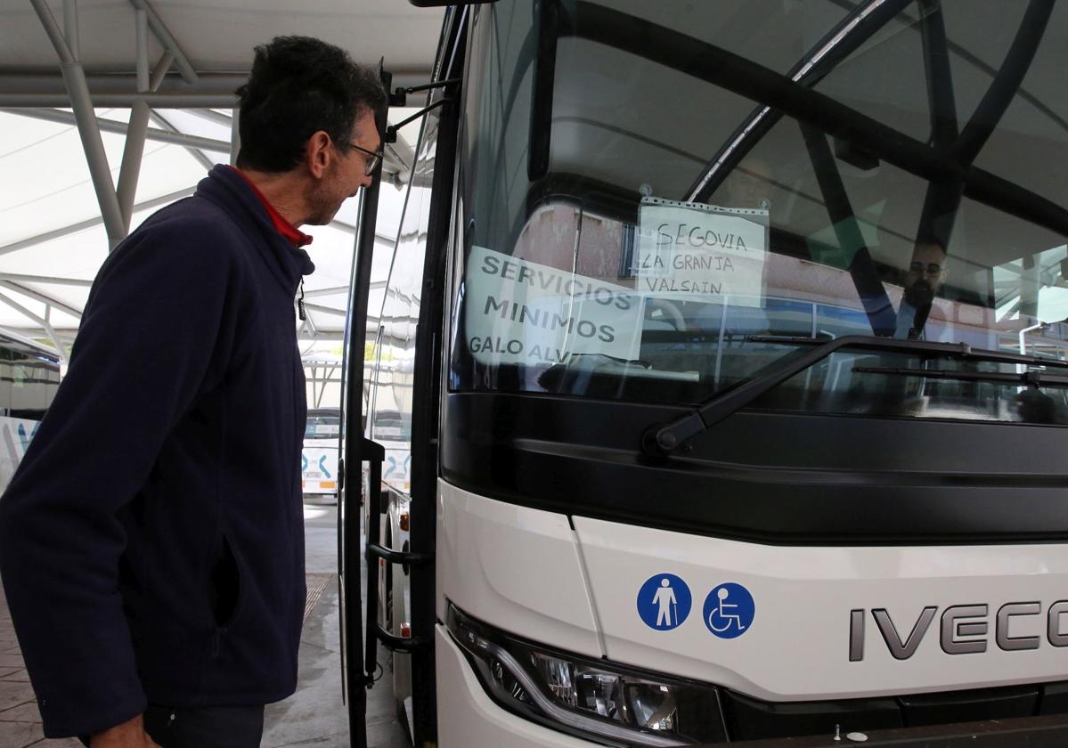 Un hombre observa un cartel que anuncia los servicios mínimos por la huelga en una línea de autobús de Segovia.