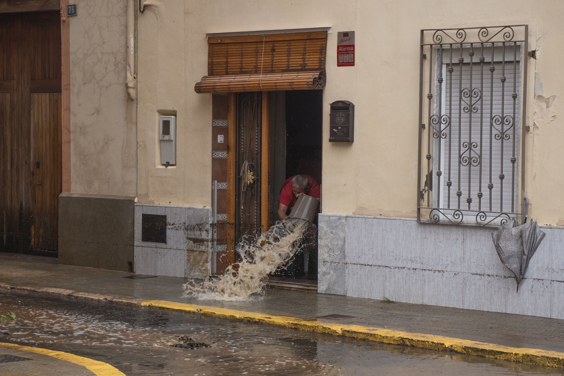 Un hombre achica agua, a 29 de octubre de 2024, en Llombai, Valencia.