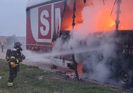 Uno de los bomberos interviniendo en la extinción de las llamas de la caja del tráiler.