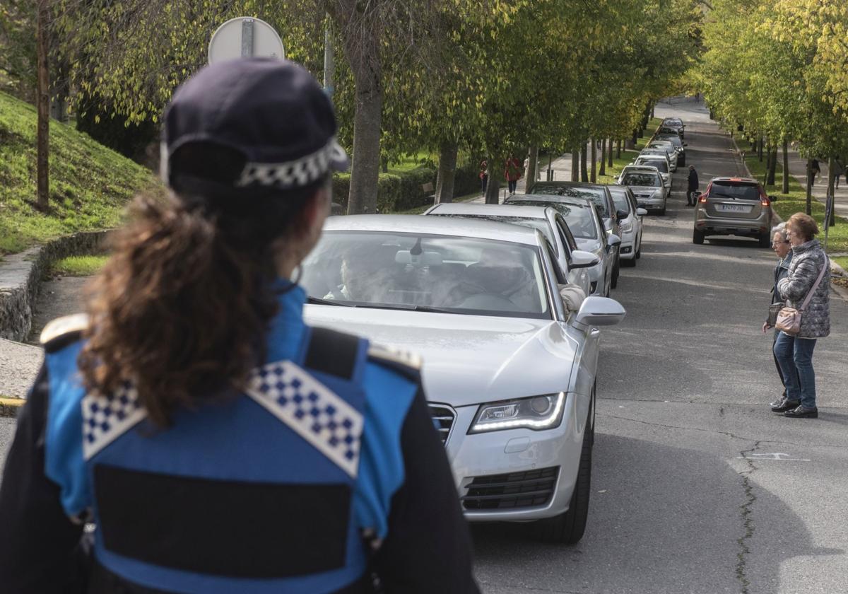 Una agente de la Policía Local controla el tráfico de acceso al cementerio.