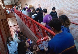 Voluntarios transportan material en cadena en el Centro Cívico El Campillo de Valladolid.