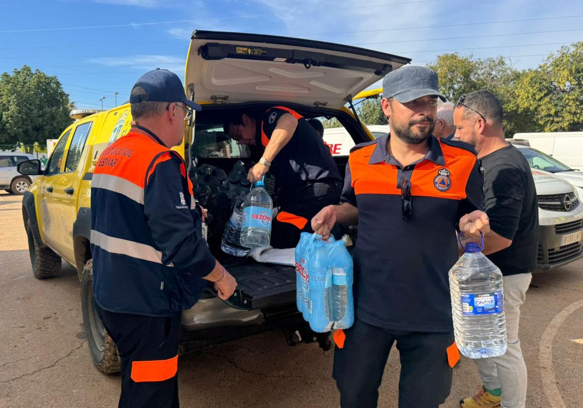 Miembros de Protección Civil de El Espinar descargan botellas de agua en uno de los pueblos más afectados.