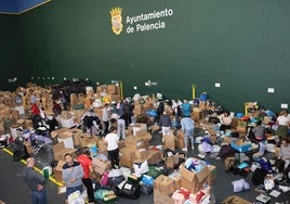 Voluntarios trabajando este martes en la organización del envío de material apilado en el Frontón de la Ensenada.