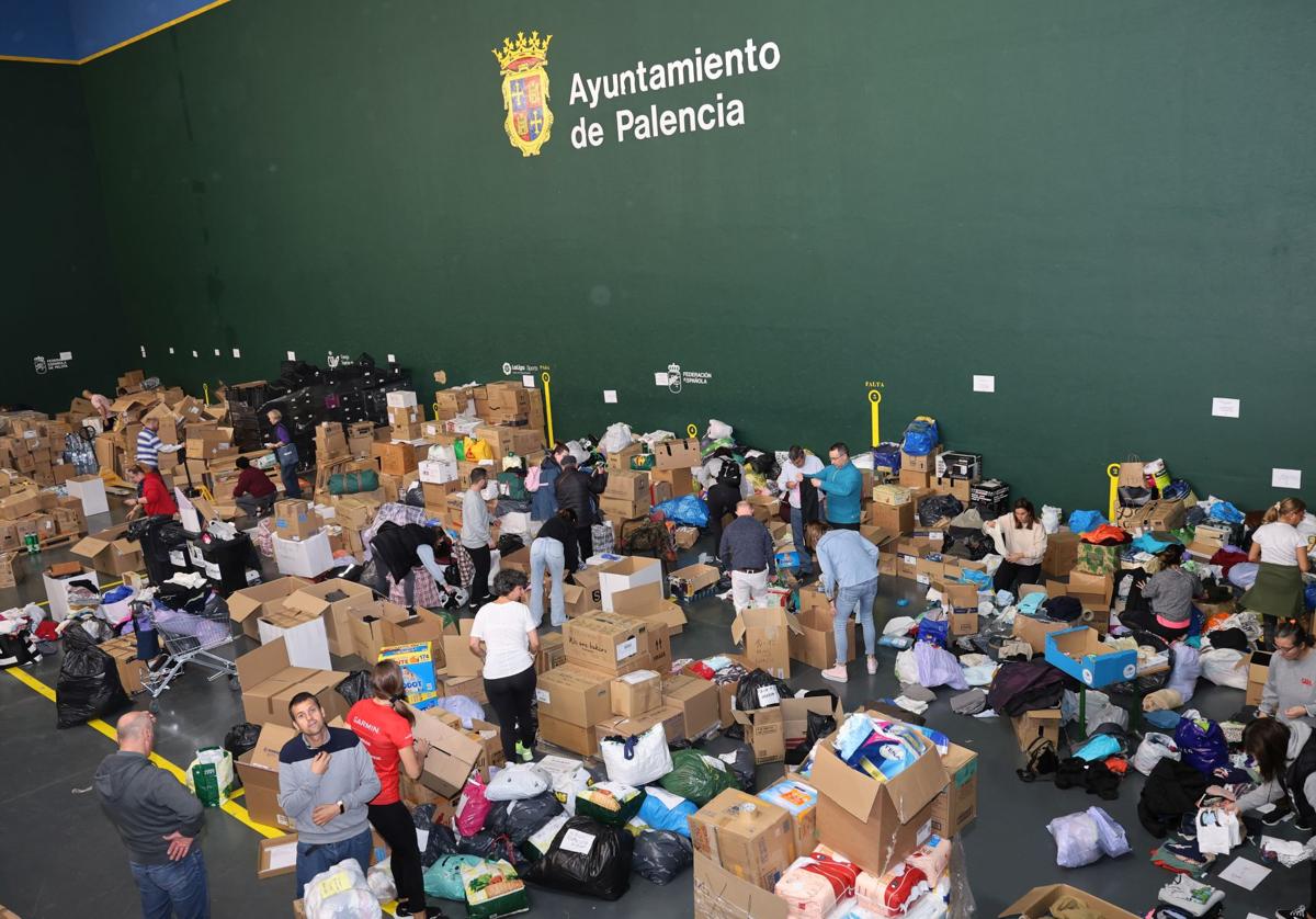 Voluntarios trabajando este martes en la organización del envío de material apilado en el Frontón de la Ensenada.