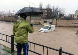 Un vecino de Cantimpalos observa una furgoneta atrapada tras la crecida de un arroyo a principios de año.