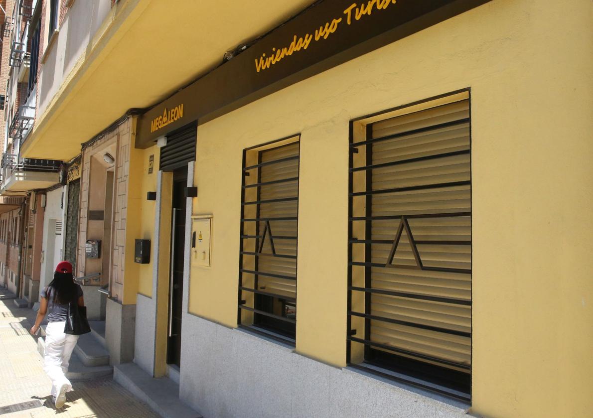 Una mujer pasea junto al acceso a un apartamento turístico.