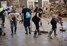 Voluntarios ayudan en la limpieza de una calle de Paiporta (Valencia).