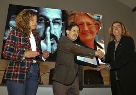 El fotógrafo recibe el premio, que le entrega la presidenta de la Diputación.