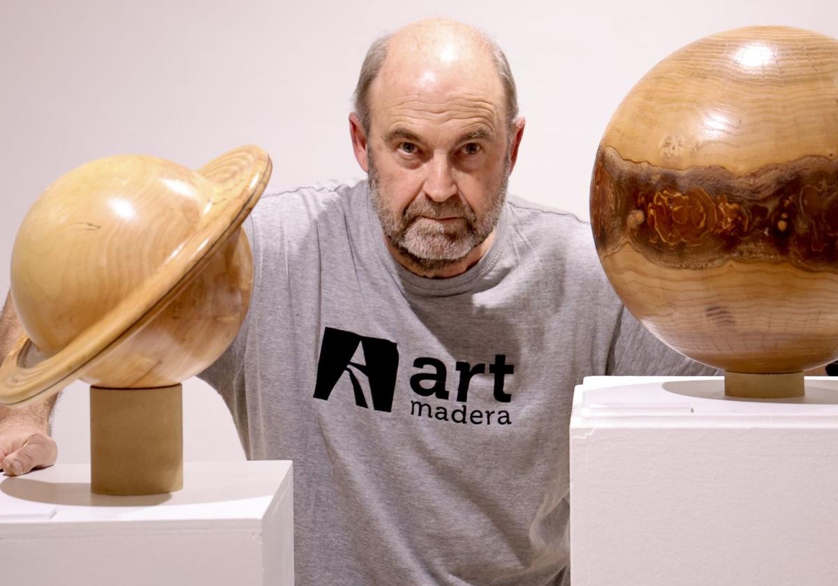 Francisco Treceño, junto a dos figuras de planetas en la exposición de la sala del Centro Regional de Artesanía de Castilla y Léon, que se puede visitar hasta el 5 de diciembre.