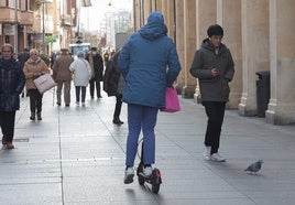 Un hombre circula en patinete por la Calle Mayor.