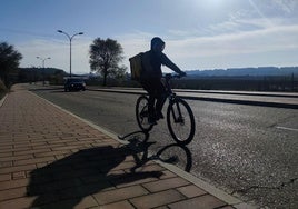 Un repartidor de Glovo sube a Zaratán por la carretera del Camino del Prado. En la acera se instalará el carril bici.