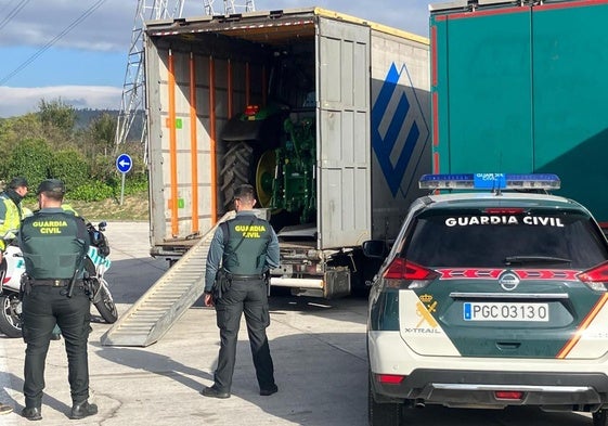 Agentes de la Guardia Civil junto al camión con los tractores robados.