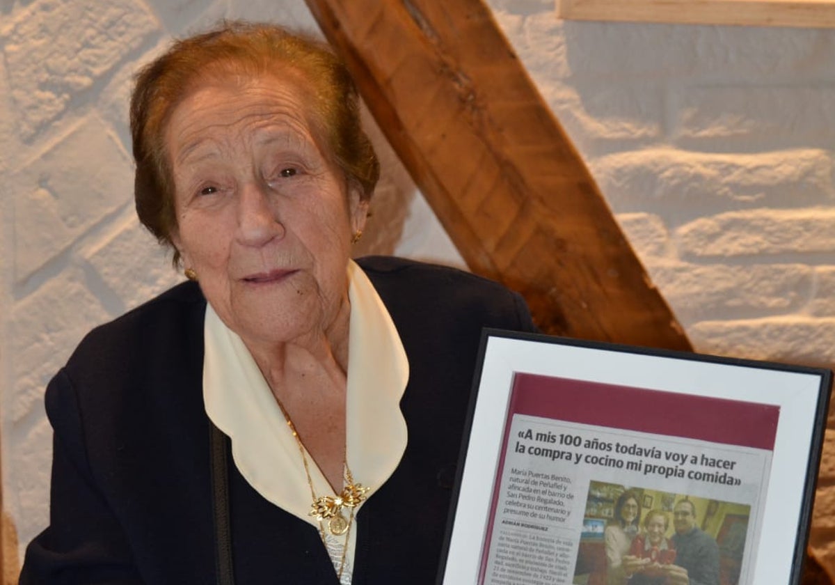 María Puertas Benito cumple 101 años posando con el artículo de El Norte de Castilla publicado el año pasado, cuando celebraba su centenario.