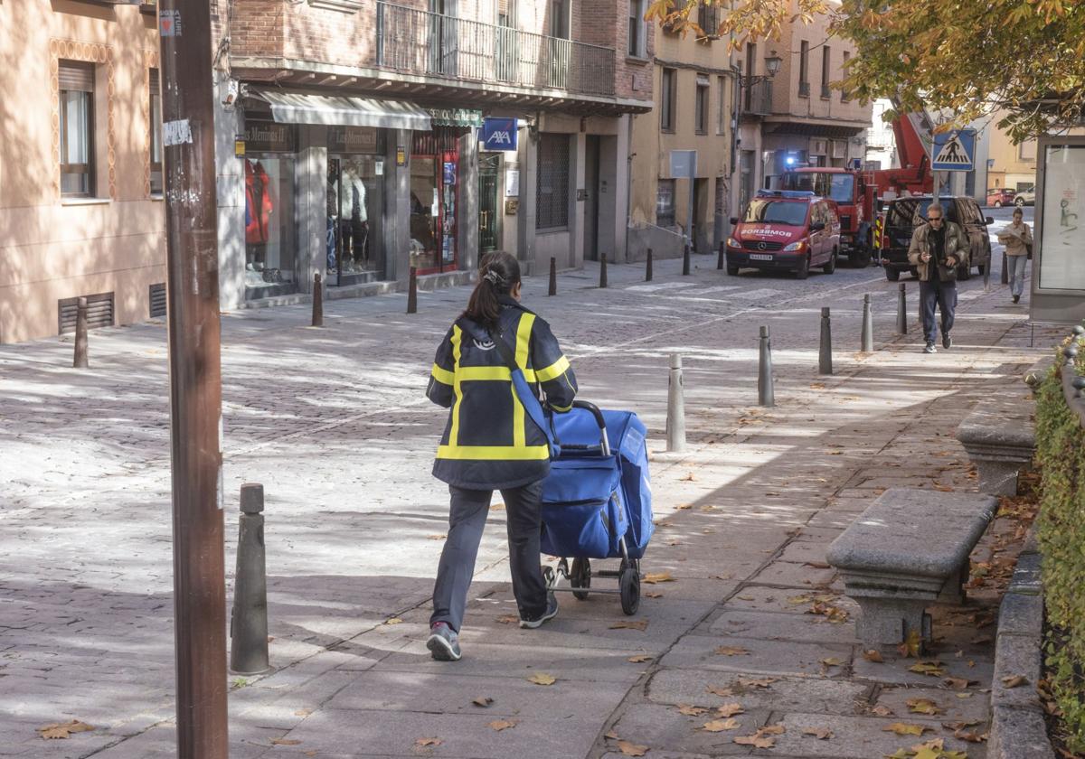 Una cartera empuja un carro de Correos en las inmediaciones de la oficina central en Segovia.