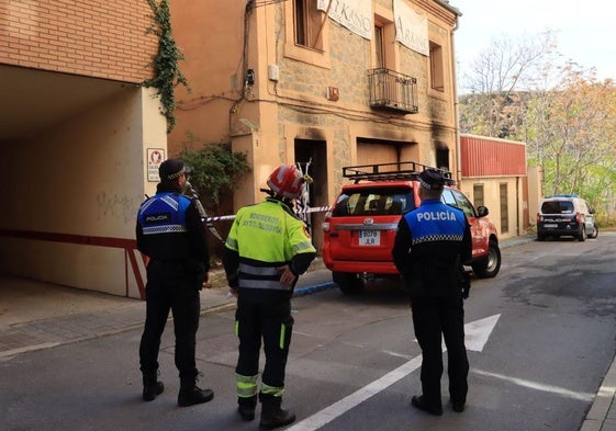 Policías locales, bomberos y agentes nacionales, inspeccionan la casa okupa incendiada esta madrugada.